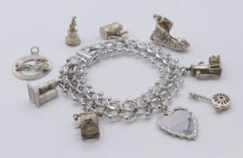 A silver charm bracelet and various charms. Bracelet 19 cm long. 63.9 grammes.