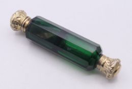 A Victorian double-ended green glass scent bottle with faceted sides and possibly silver gilt tops.