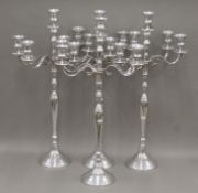 Four large metal candelabra. Each 85 cm high.