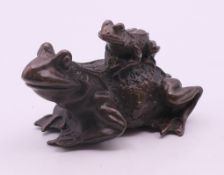 A bronze frog with a froglet on its back. 7 cm long, 4.5 cm high.