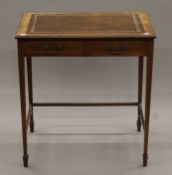 An Edwardian leather-topped two-drawer side table. 67 cm wide.