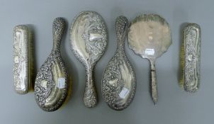 Four silver-backed brushes and two silver-backed mirrors. The larger mirror 26.5 cm long.