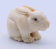 A bone netsuke formed as a rabbit/hare. 3 cm high.