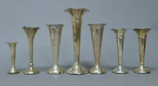 Seven various silver fluted bud vases. The largest 21 cm high.