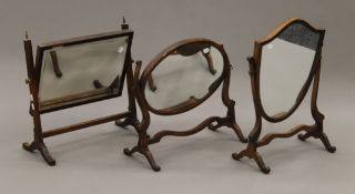 Three 19th century mahogany toilet mirrors. The largest 51 cm wide.