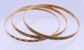 Three 9 ct gold bangles. Each 6 cm inner diameter. 15.9 grammes.