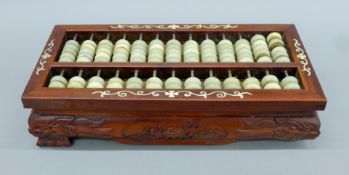 A Chinese abacus with jade beads. 34 cm long.