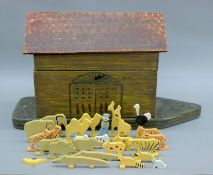 A painted wooden toy Noah's Ark with figures and animals. 63 cm long.