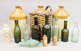 Three stoneware flagons and a collection of various bottles. The largest 35 cm high.