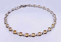 A 9 K white gold, diamond and citrine bracelet. 19 cm long. 13.9 grammes total weight.