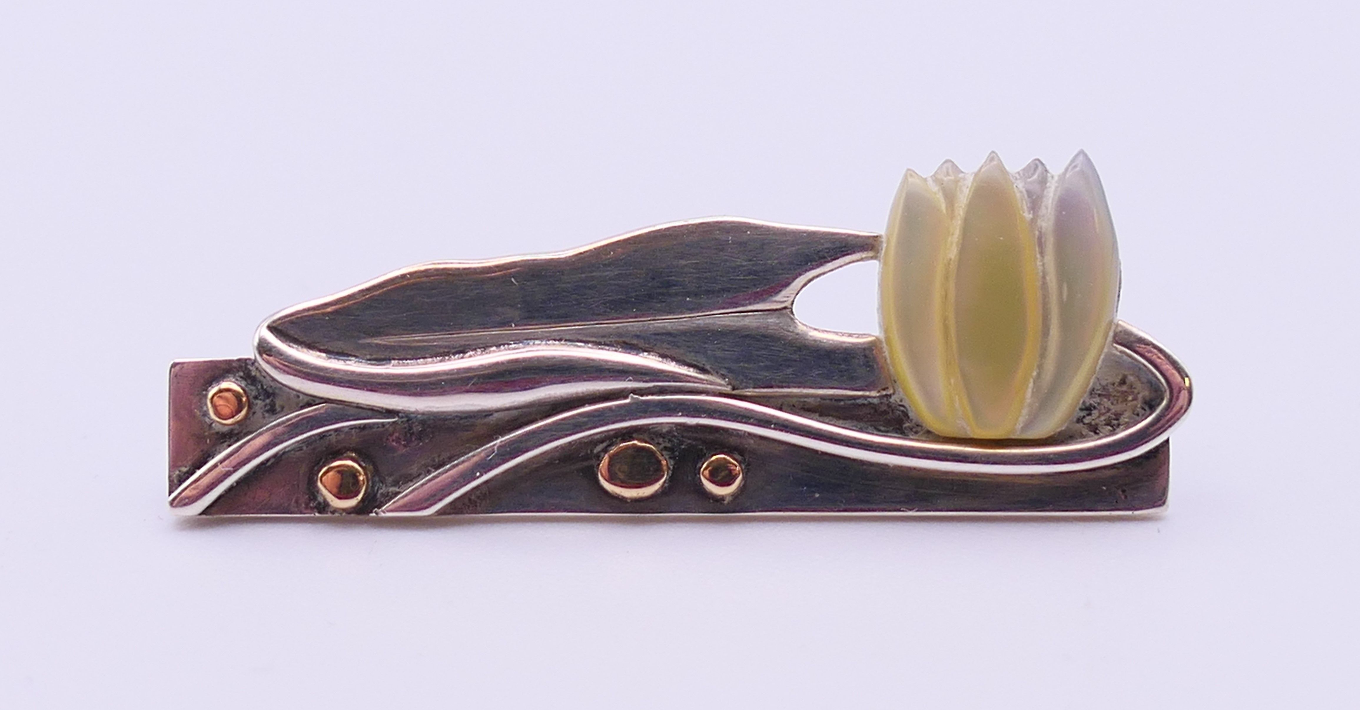 An Ann Powell handmade one-off silver, gold and mother-of-pearl brooch decorated with a lily. 3.