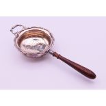 A silver tea strainer with turned wooden handle. 17 cm long. 48.3 grammes total weight.