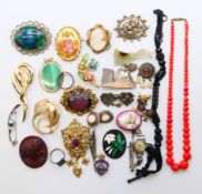 A silver-plated cigarette box containing a quantity of costume jewellery, including brooches,