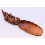 A carved wooden spoon. 18 cm long.