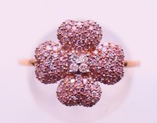 A 9 ct pink and white diamond clover-form ring. Ring size N/O. 2.3 grammes total weight.