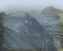 A photograph of a bi-plane over mountains, framed and glazed. 20 x 25 cm.