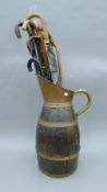 A large brass-bound oak ewer containing a quantity of walking sticks and umbrellas.