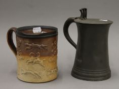 An English salt-glazed stoneware hunting mug and a 19th century pewter lidded 1 quart tankard,
