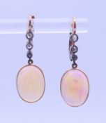 A pair of unmarked 9 ct gold opal and diamond earrings. 3 cm high.