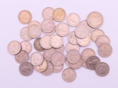 A quantity of sixpences and a shilling coin.