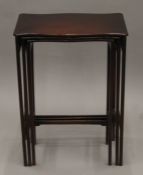 A Victorian mahogany nest of three serpentine tables. 50 cm wide.