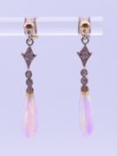 A pair of silver and opal drop earrings. 3 cm high.