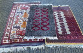 Three small red ground rugs. The largest 170 x 100 cm.