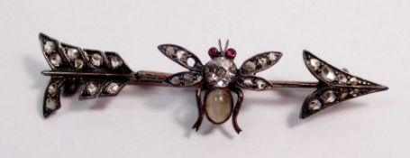 An antique silver arrow form brooch with bee set old cut diamonds, moonstone body and ruby eyes, a/