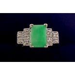 A Chinese Art Deco style white metal ring set jade plaque flanked by ten stepped diamonds, size N,