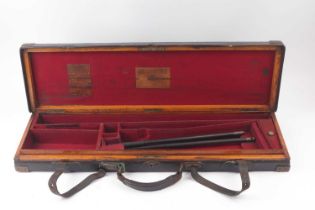 An oak and leather gun case with brass corners by James Purdey & Sons, with claret baize lined