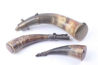 Polished horn powder flask with brass mounts and band, three suspension rings and brass base;