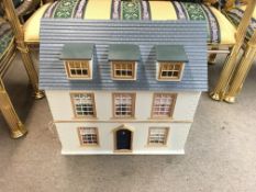 A large dolls house with lots of furniture and fit