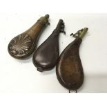 Two Antique leather and brass shot flasks and a co