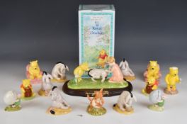 Fourteen Royal Doulton Walt Disney Winnie the Pooh figures including Eeyore Loses a Tail tableaux