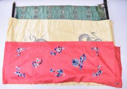 Two embroidered Chinese silk panels, the largest 102 x 67cm and a similar length of fabric, length