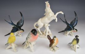 A collection of Karl Ens figures comprising birds including a pair of swifts, and a rearing horse
