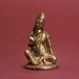A small Tibetan gilt-bronze/copper alloy figure of a seated Lama, probably Tsongkhapa,