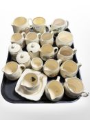 A quantity of china souvenir milk jugs and preserve pots.