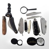 A group of folding pocket knives, pen knife, magnifying glasses, small coal figure,