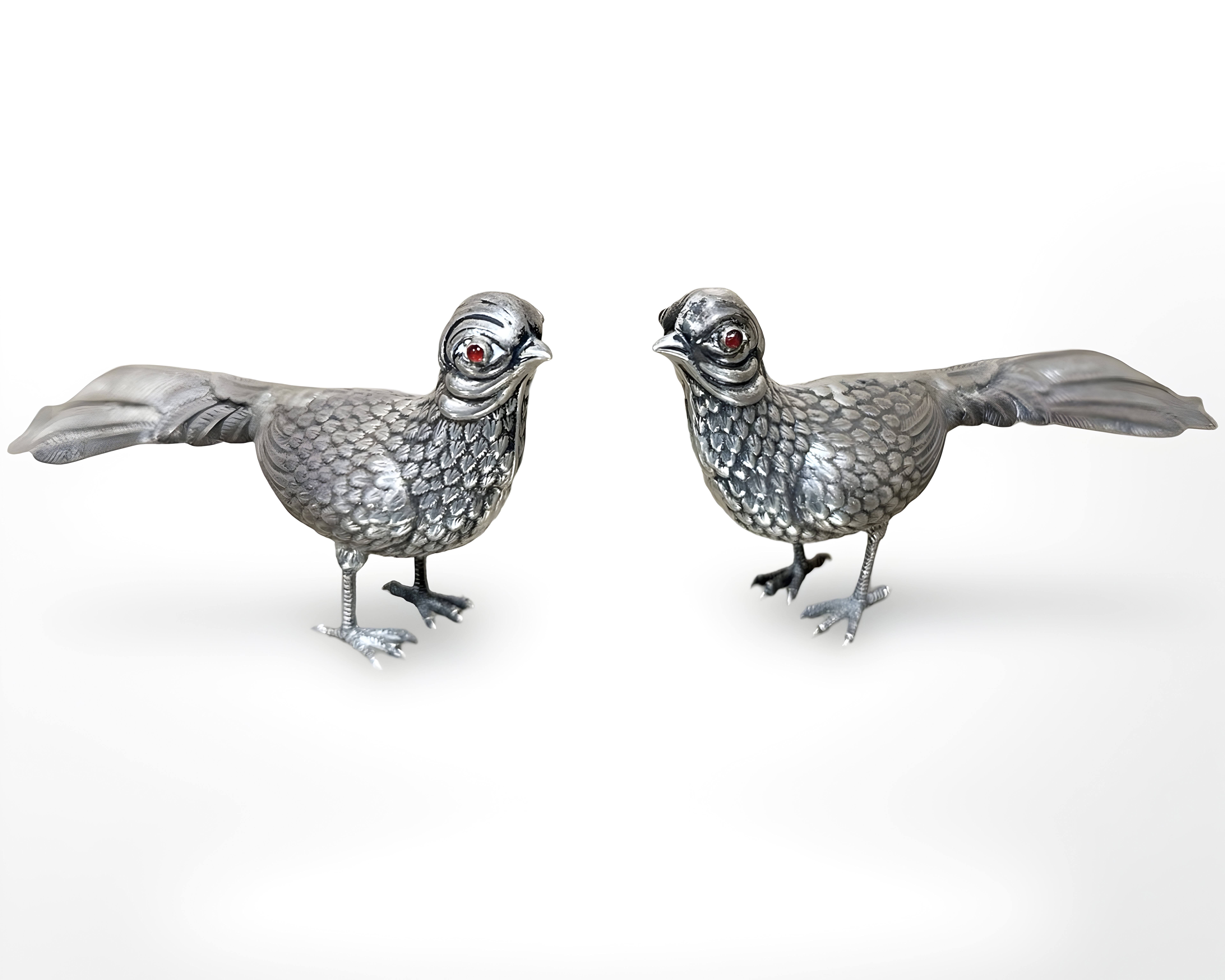 A pair of antique Portuguese silver figures of pheasants with garnet eyes, approximate length 17 cm.