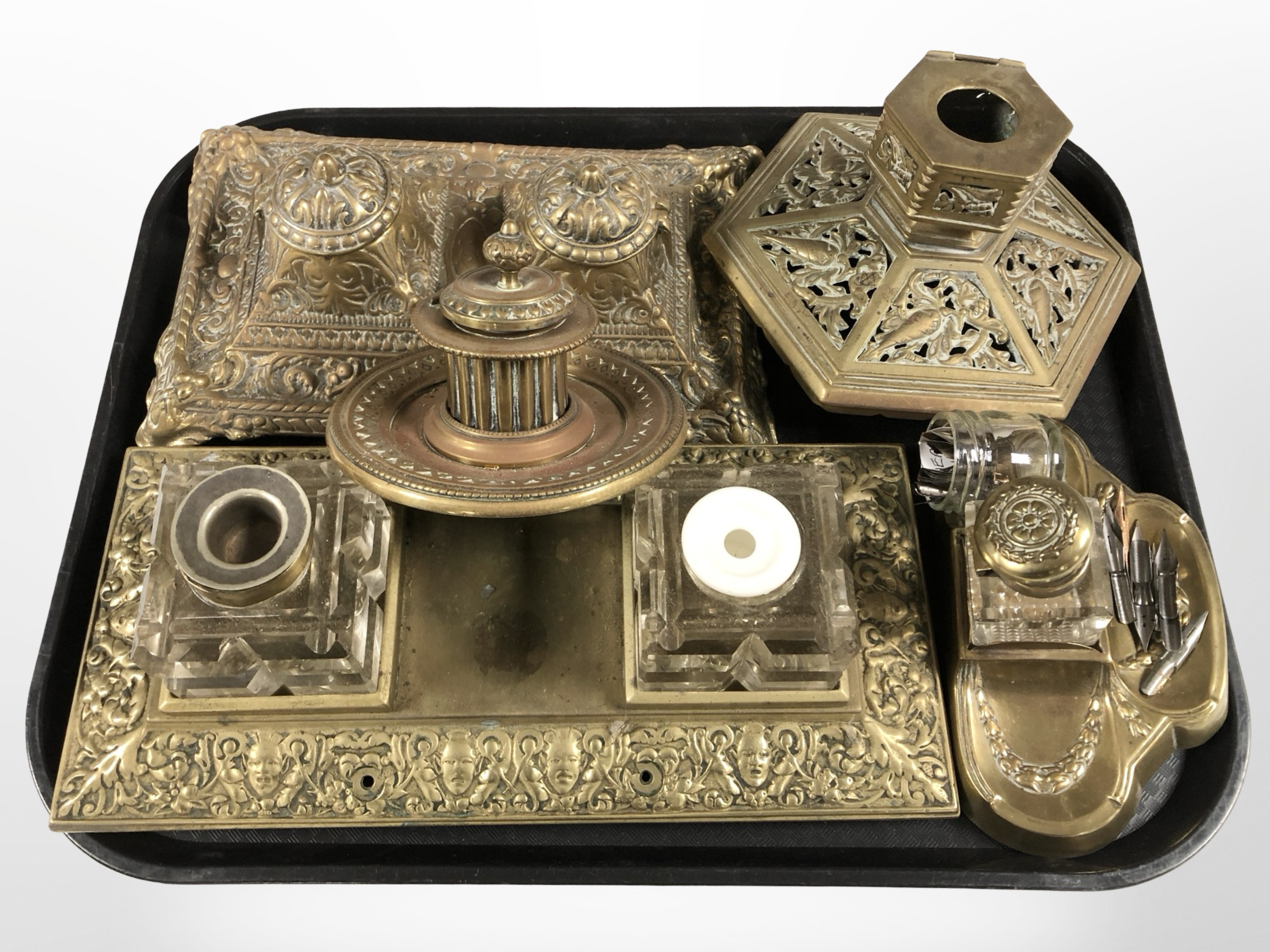 A group of ornate brass desk stands and ink wells.