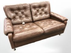 A late 20th century Danish button brown leather two seater settee on chrome feet,