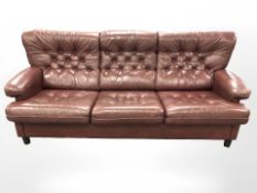 A late 20th century Danish Burgundy buttoned leather three piece lounge suite comprising of three