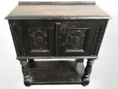 A carved and stained oak double door side cabinet,