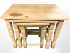A nest of three blond oak tables,