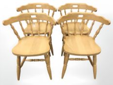 A set of four pine spindle back dining chairs.
