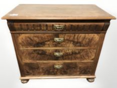 A 19th century continental walnut four drawer chest on bun feet,