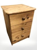 A pine three drawer bedside chest,
