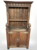 A late 19th century continental carved oak and pine bookcase, fitted cabinet beneath,