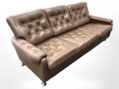A late 20th century Danish button brown leather three settee seater on chrome feet,